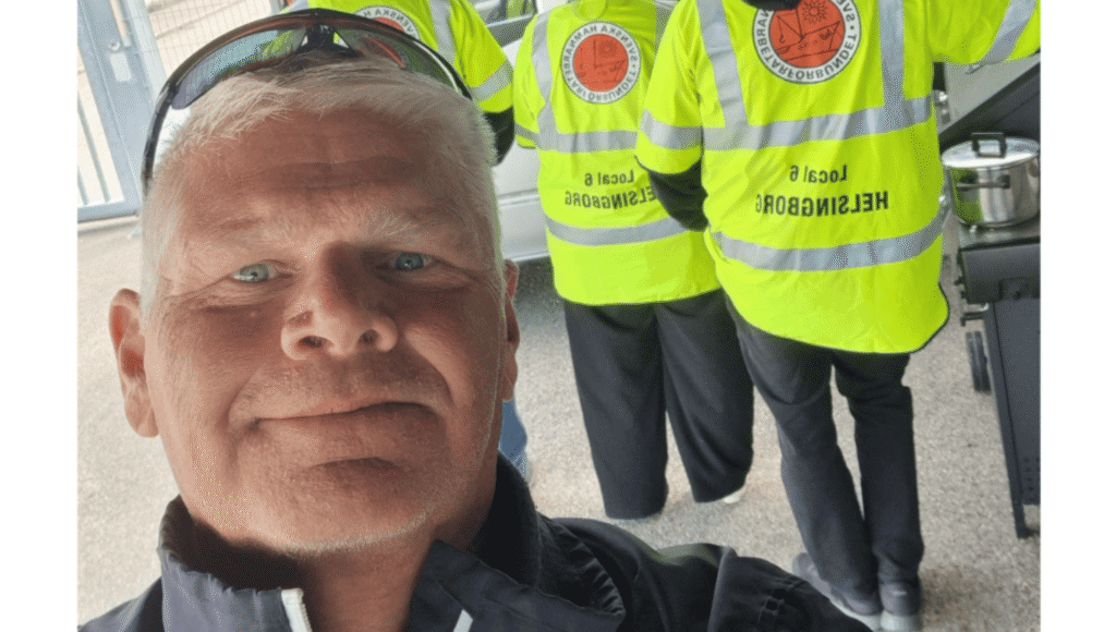 Man med reflexvästar i bakgrunden
