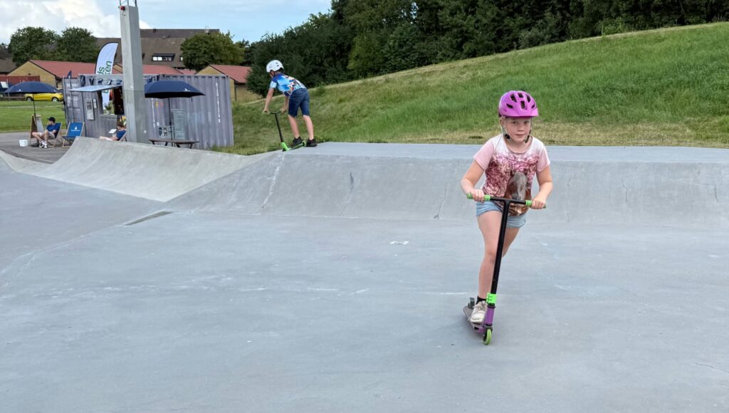 Flicka på en kickbike i en skatepark