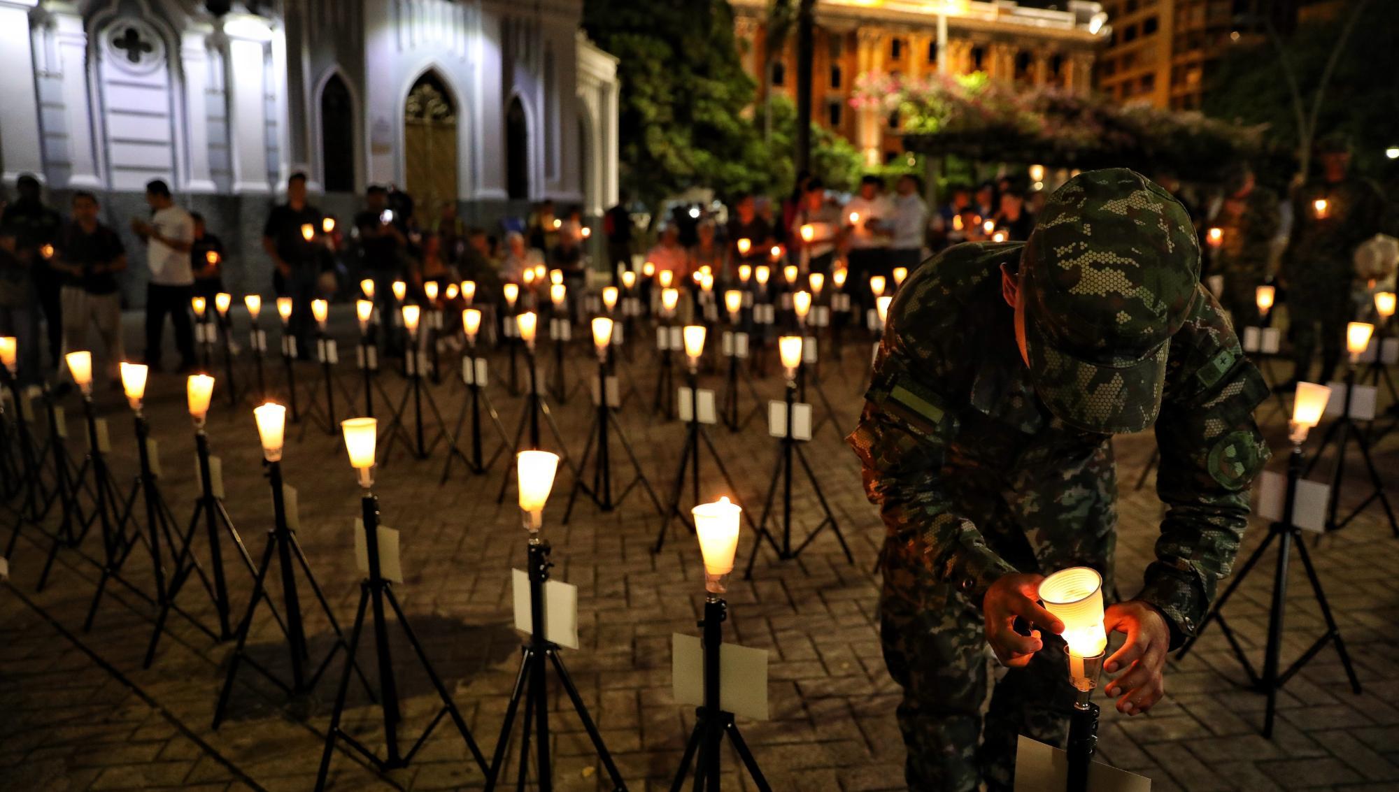 En militär tänder ett ljus under en minnesstund efter den tragiska flygolyckan i Puerto Leguízamo i Putumayo-regionen under måndagen. Minst 66 personer uppges ha dött när ett plan från den colombianska militären kraschade. Foto: Santiago Saldarriaga /AP/TT