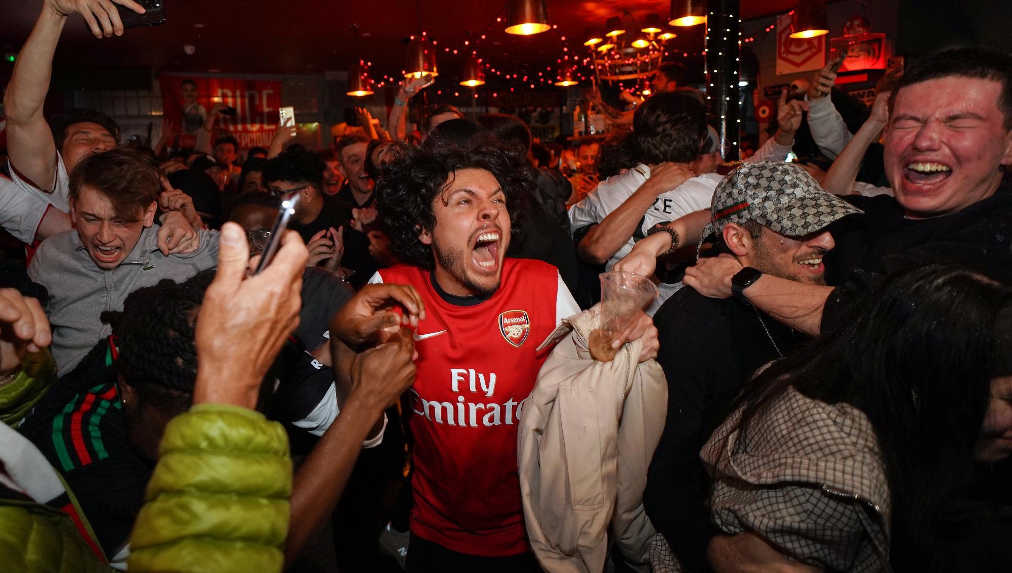 Supportrar jublar efter att det under tisdagskvällen stod klart att Arsenal vinner Premier League för första gången på 22 år. Foto: Alberto Pezzali/TT