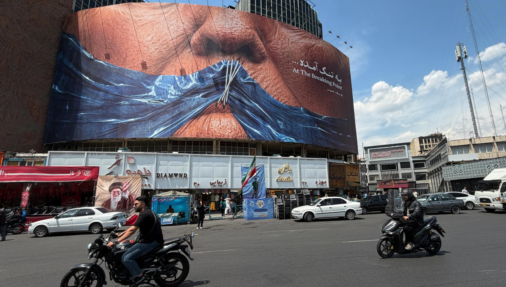 En stor billboard med Donald Trumps ihopsydda läppar täcker en byggnad vid ett trafikerat torg i Teheran mitt under den pågående konflikten. Foto: Vahid Salemi /AP/TT