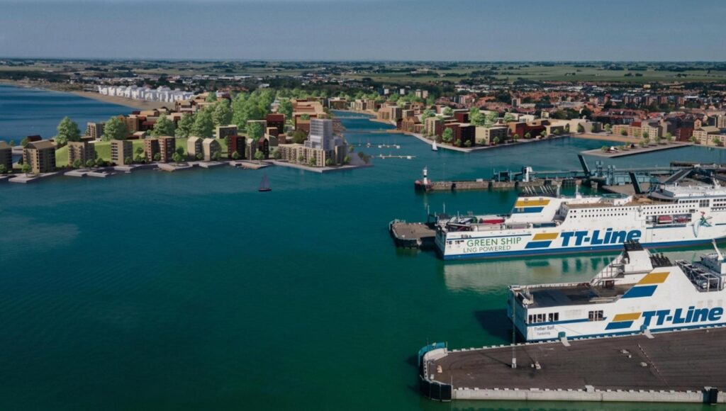 Flygbild över en visualisering av ny bebyggelse vid en hamn med stora färjor i förgrunden.
